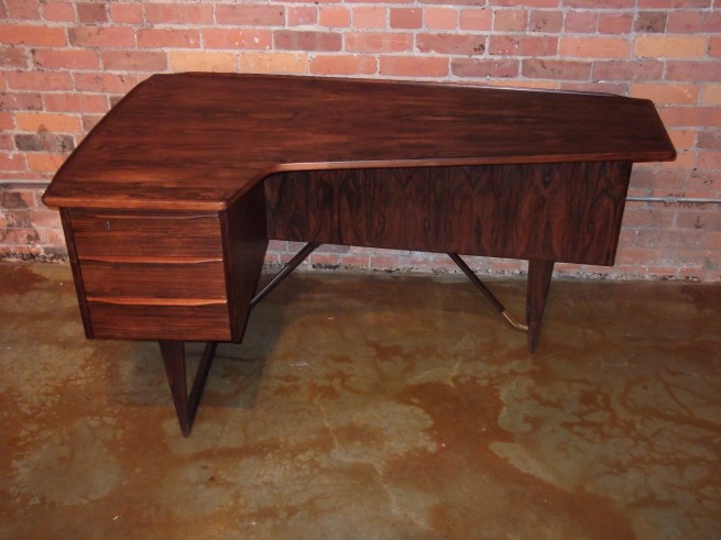 Outstanding Mid-century modern Rosewood desk – designed by Peter Lovig Nielsen – Denmark – design year 1956 – this beauty has incredibly lovely features including a deep rich grain – a unique L shape top a raised lip – dovetailed drawers – handsome brass bar at base along with a locking bar cabinet on the backside with a bookshelf as well -this stunner measures – 58″L x 34″D x 29″H – $2,200